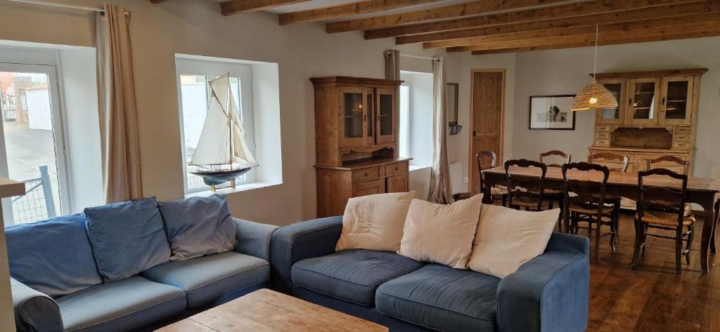a living room with a couch and a dining room at Maison à la campagne. in Audembert