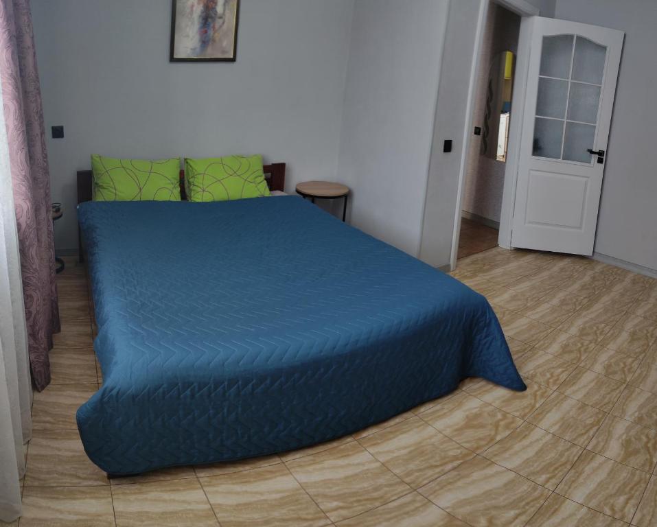 a bed in a room with a blue comforter at Smart Apartment на Соборной 23 in Kremenchuk