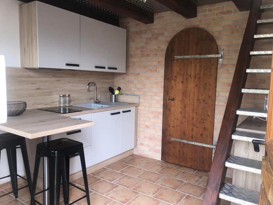 - une cuisine avec une table et une porte en bois dans l'établissement Le cocon de David, à Alès