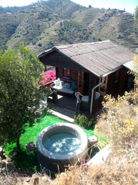 a small house with a large tub in the grass at Romantic Mountain cabin with Spa in Caserío Carraspite