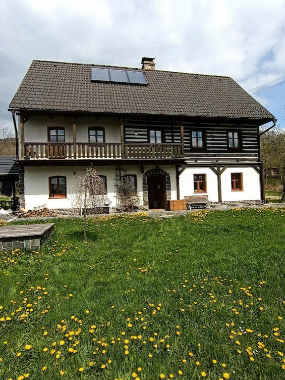 a large house with a large yard with yellow flowers at Cottage Kolné in Stvolínky