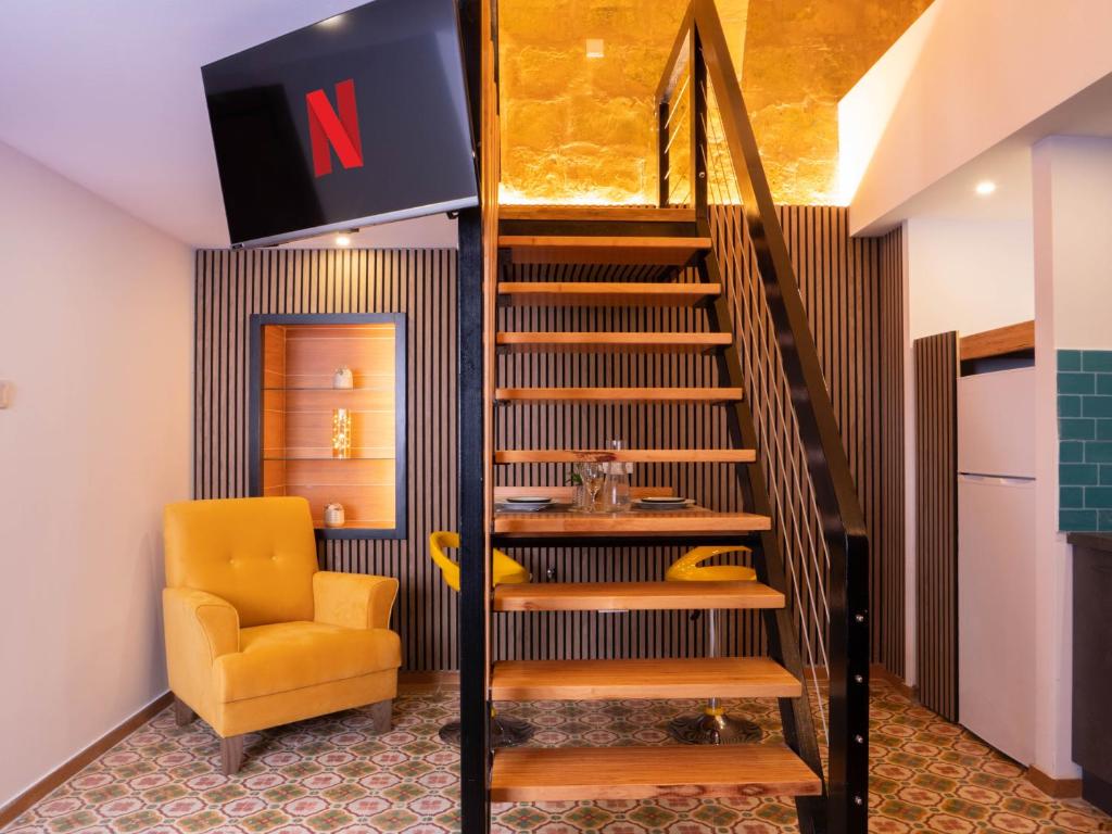 spiralne schody w pokoju z żółtym krzesłem w obiekcie Ursula suites - self catering apartments - Valletta - By Tritoni Hotels w mieście Valletta