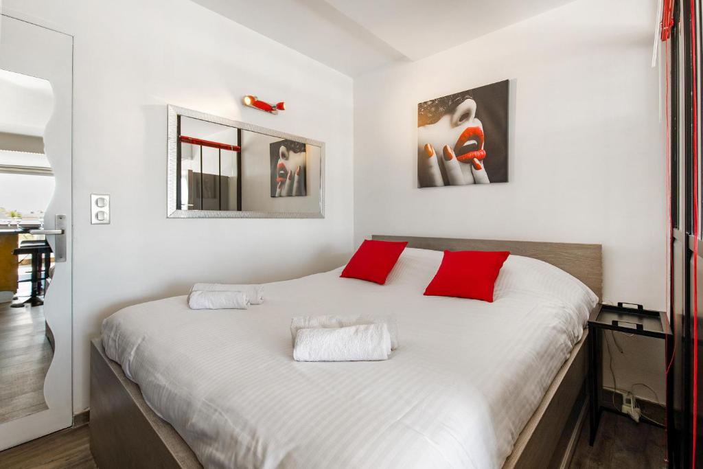 une chambre avec un grand lit blanc avec des oreillers rouges dans l'établissement Village Naturiste r4n - Dream PN 5 coursives, au Cap d'Agde