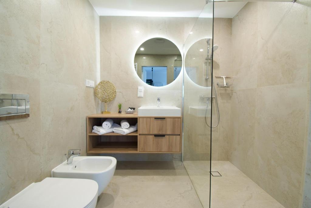 羅戈沃的住宿－Baltic Seasons by Alluxe Boutique Apartments，浴室设有卫生间水槽和镜子