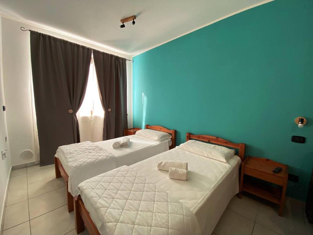 2 Betten in einem Schlafzimmer mit blauer Wand in der Unterkunft Agriturismo San Giuliano dei fratelli Giai in Susa