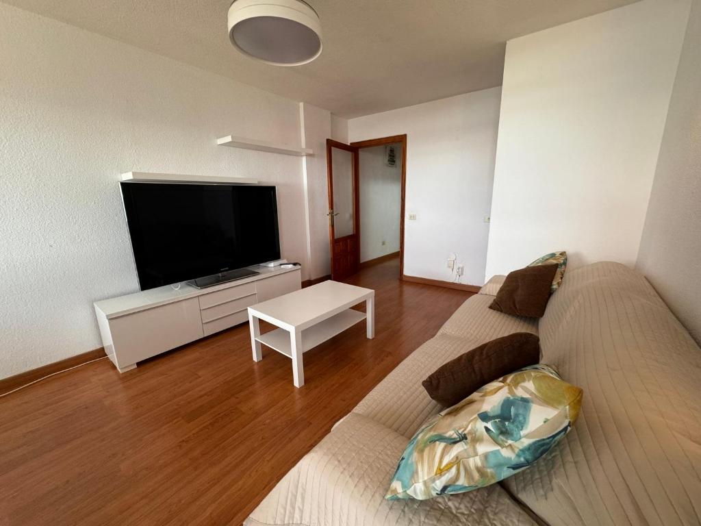 a living room with a couch and a flat screen tv at Alquilaencanarias Caletillas Vista al Mar in Candelaria