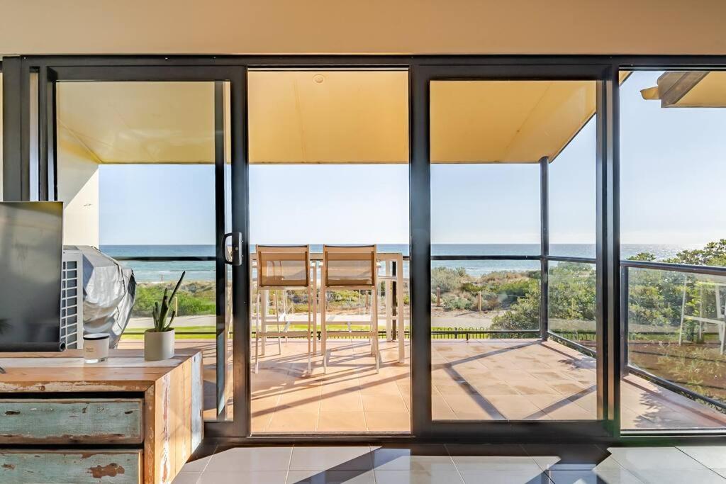 Port AdelaideにあるLuxurious 3 bedroom beachfront - panoramic viewsの海の景色を望むリビングルーム(ガラスのスライドドア付)