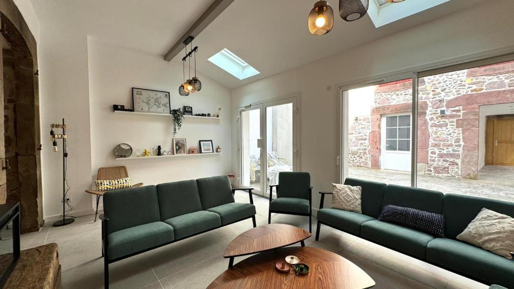 ein Wohnzimmer mit einem grünen Sofa und einem Tisch in der Unterkunft Maison LAURENTZENIA in Saint-Jean-Pied-de-Port