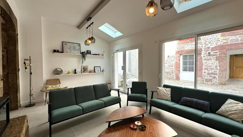 a living room with a green couch and a table at Maison LAURENTZENIA in Saint-Jean-Pied-de-Port