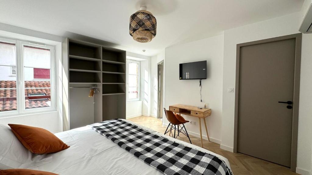 a bedroom with a bed with a checkered blanket on it at Maison LAURENTZENIA in Saint-Jean-Pied-de-Port