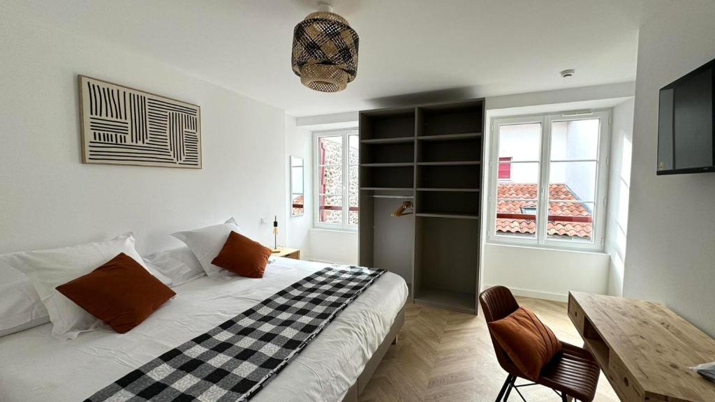 a bedroom with a bed and a table and a window at Maison LAURENTZENIA in Saint-Jean-Pied-de-Port