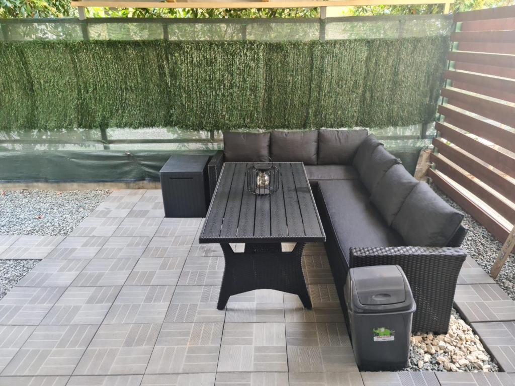 a patio with a couch and a table with a trash can at Apartament Deea in Mamaia Nord