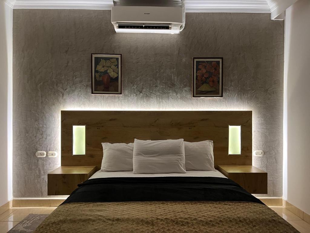 ein Schlafzimmer mit einem großen Bett mit zwei Nachttischen in der Unterkunft Delta Sharm in Sharm El Sheikh