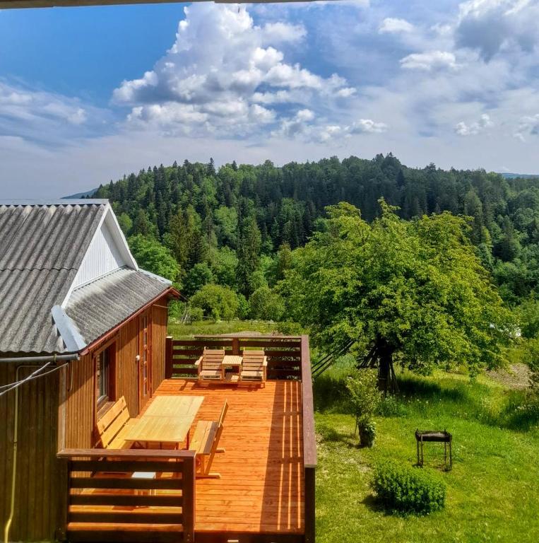 a large deck with chairs and a house at Будиночок для щастя in Yaremche