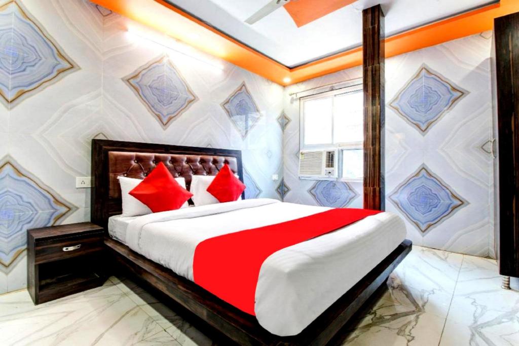 a bedroom with a large bed with red pillows at Krishna Palace Charbagh Lucknow By GRG in Lucknow