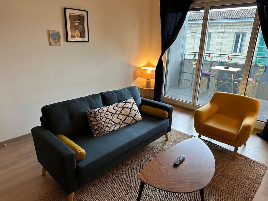 a living room with a blue couch and a chair at Le cocon bordelais - Cité du vin in Bordeaux