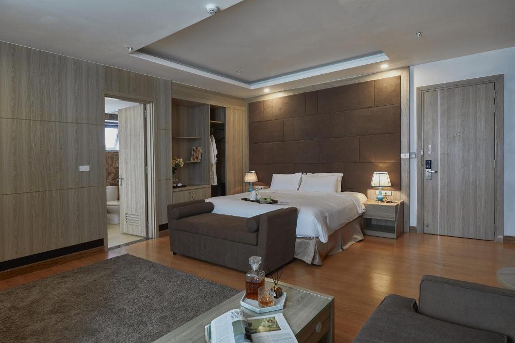 タムダオにあるGenuss Tam Dao - Hideaway Retreatsのベッドとソファと椅子のある寝室