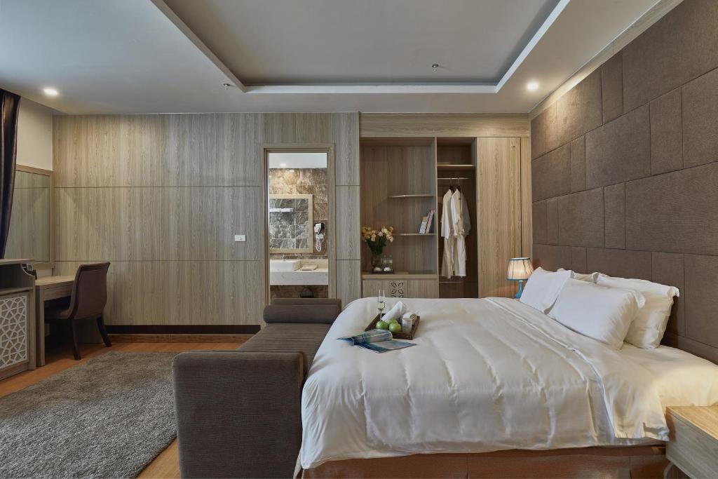 1 dormitorio con 1 cama blanca grande y escritorio en Genuss Tam Dao - Hideaway Retreats, en Tam Ðảo