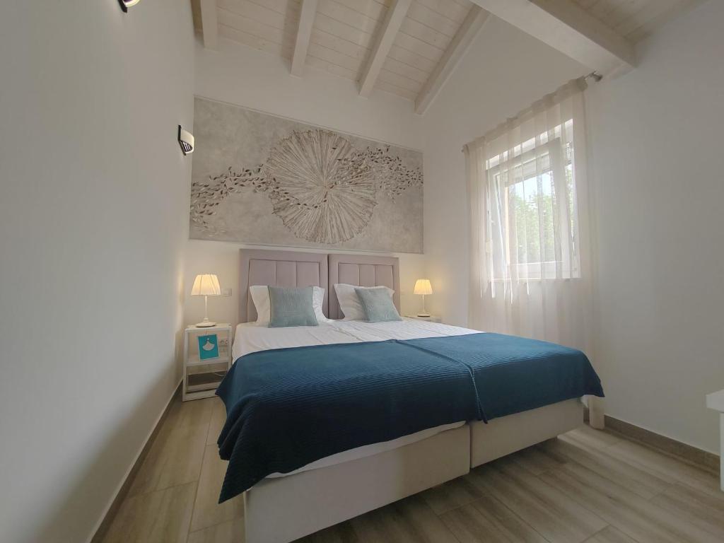 a bedroom with a large bed with a blue blanket at Villa Mila Rovinj in Rovinj
