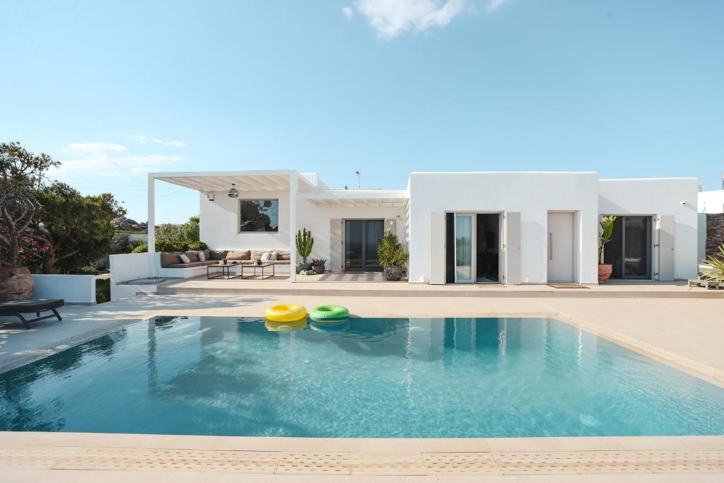 eine Villa mit einem Pool vor einem Haus in der Unterkunft Villa Paraga in Platis Gialos