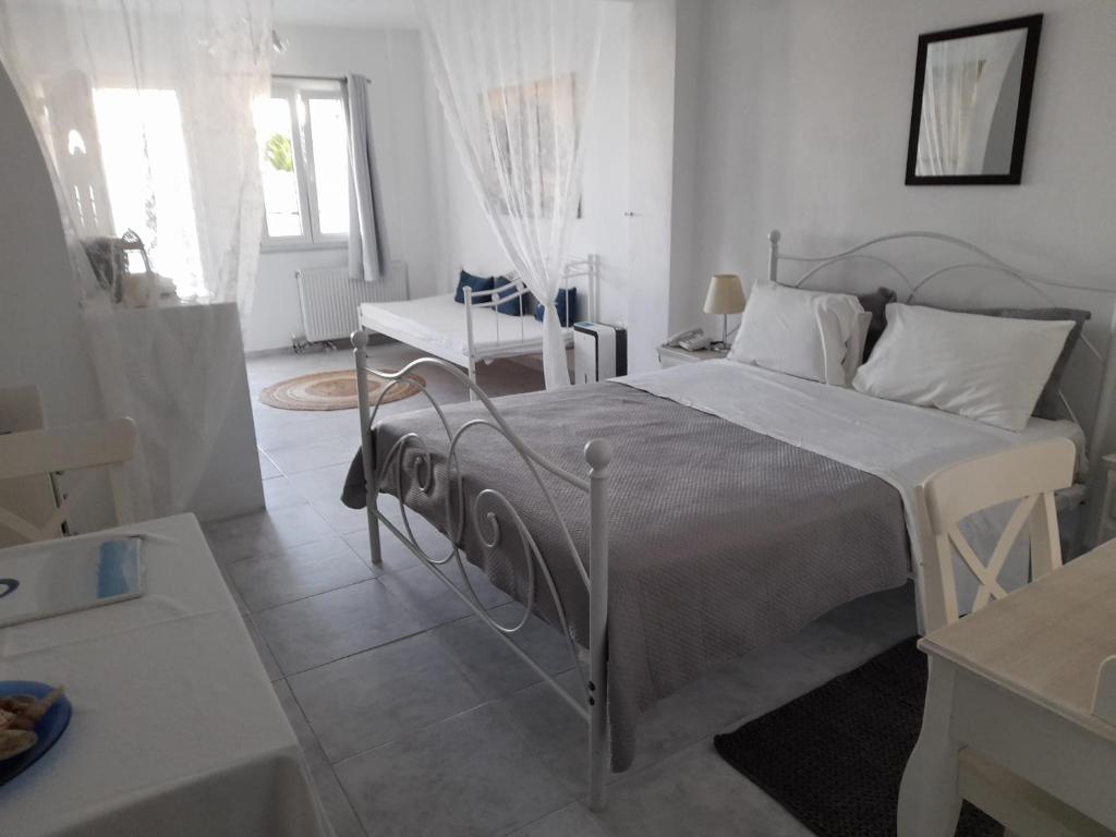sypialnia z łóżkiem, stołem i krzesłem w obiekcie Sea paradise villas - Seaside & private jacuzzi w mieście Oia
