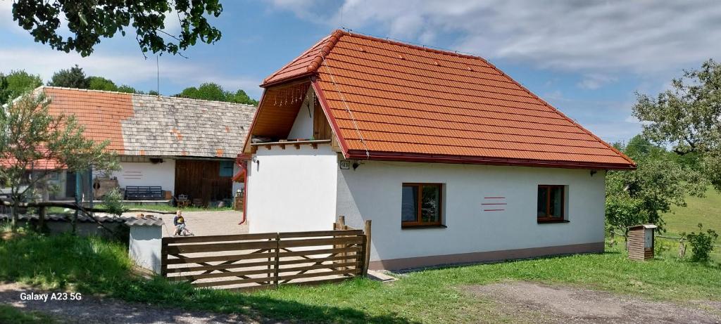 una pequeña casa blanca con techo naranja en Chata Chotár Nová Baňa, en Veľká Lehota