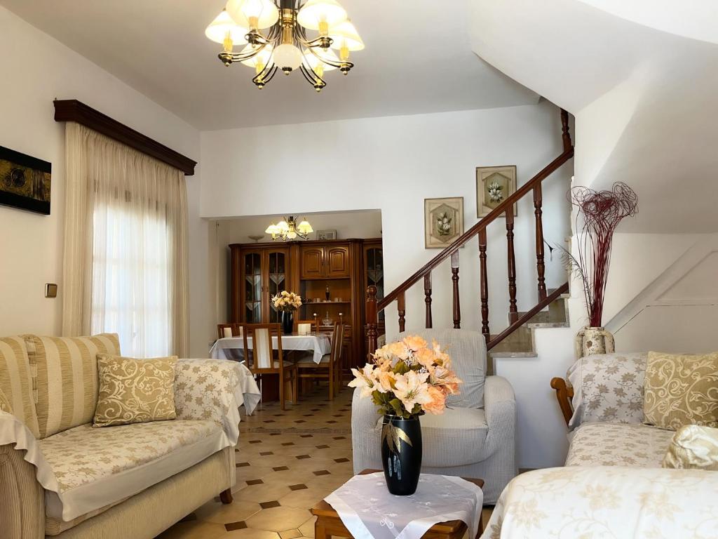 a living room with two couches and a vase of flowers at katerina`s house in Kefalos