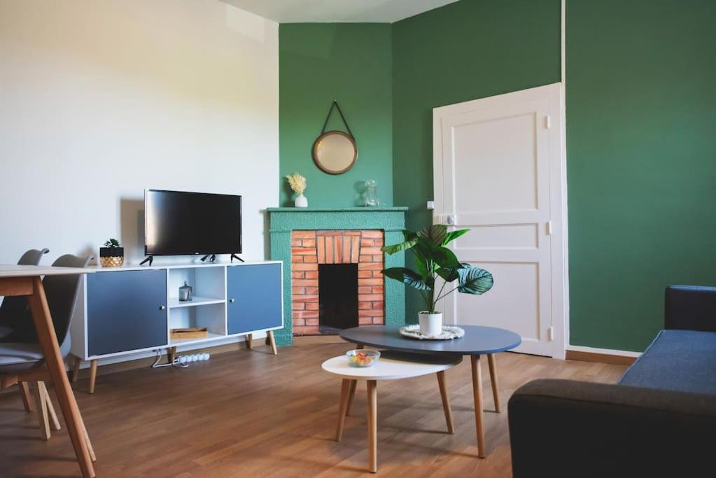 Elle comprend un salon avec des murs verts et une cheminée. dans l'établissement Le St Gemmes : Appartement T3, à Sainte-Gemme-sur-Loire