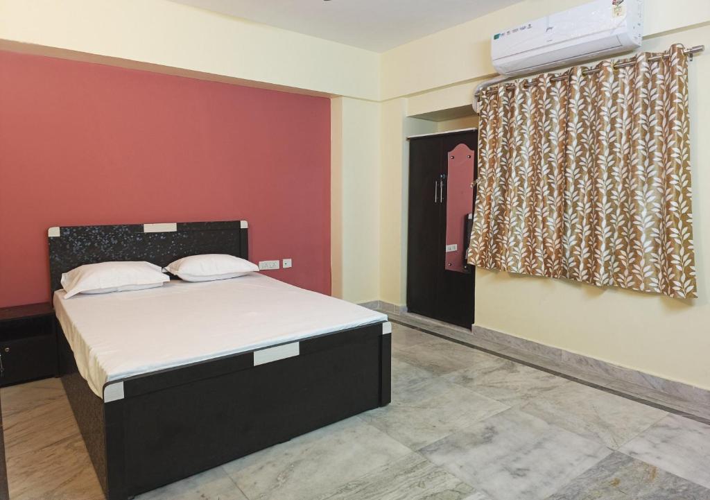 27 Degree Hotel في جمشيدبور: غرفة نوم بسرير وجدار احمر