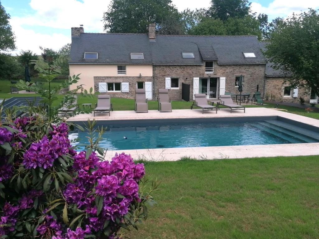 a house with a swimming pool and purple flowers at Les gîtes de l'étang de la Forêt 2 in Brandivy
