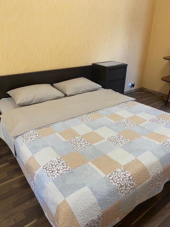 a bed in a bedroom with a checkered blanket at Апартаменты в центре с парковкой in Cherkasy