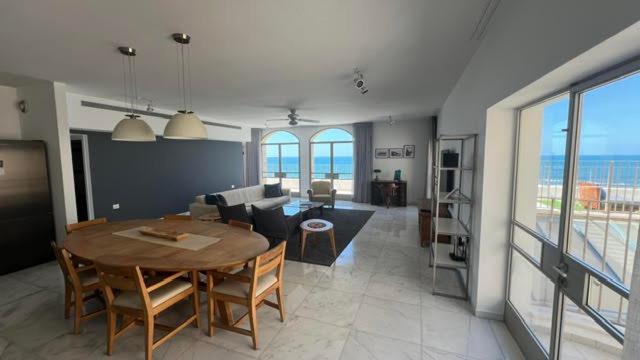 ein großes Wohnzimmer mit einem Tisch und einem Sofa in der Unterkunft Casa Nova - Luxury Suites & Boutique Apart-Hotel in Tel Aviv