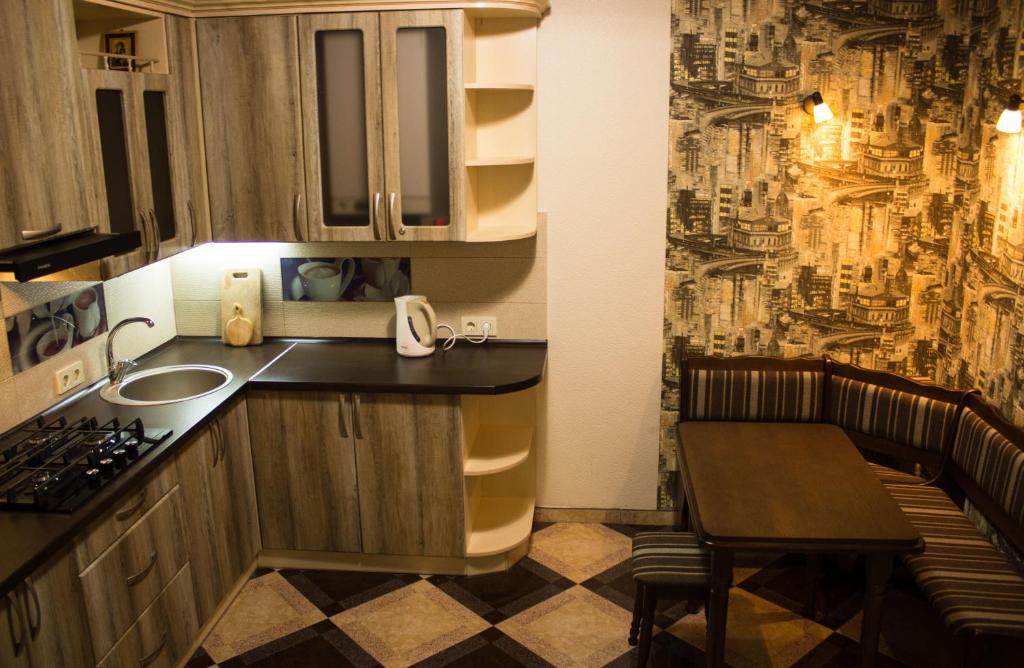 een keuken met een wastafel en een tafel in een kamer bij Hostel Q ,15 хв до жд вокзалу in Lviv