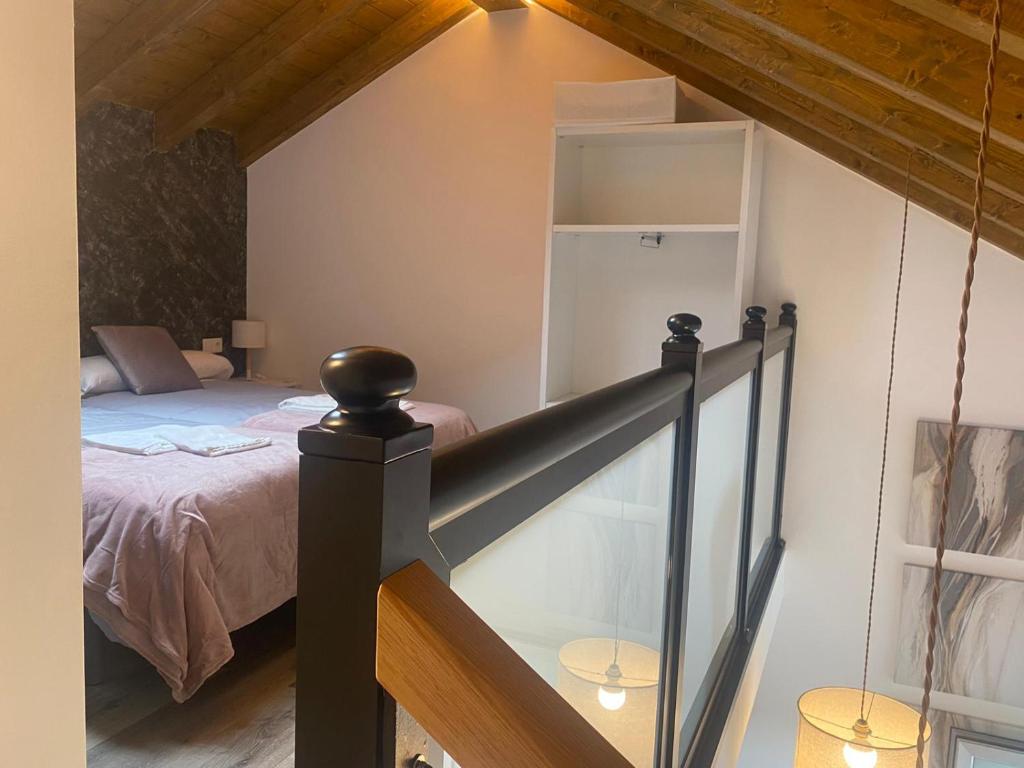 Schlafzimmer im Dachgeschoss mit einem Bett und einer Treppe in der Unterkunft Casa de Campo Cruz de Pedra in Portomarin