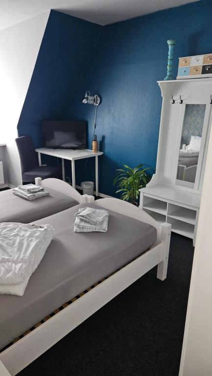 1 dormitorio con 2 camas y pared azul en Ferienwohnung Lehmann en Wolfenbüttel