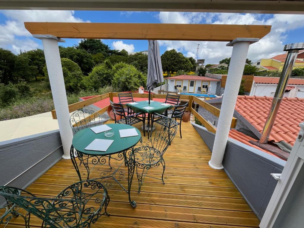 a patio with tables and chairs on a deck at Sun House III - Near Sintra - Kitchen - Pool in Mem Martins