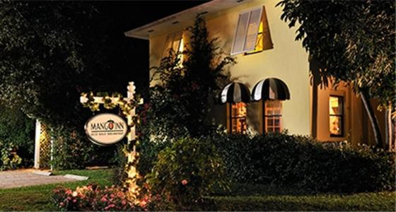 a house with a sign in front of it at Mango Inn Bed and Breakfast in Lake Worth