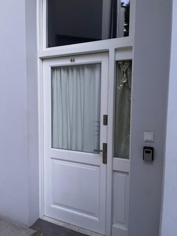 a white door with a window in a building at Charming studio apartment in the heart of the Jewish District! in Kraków