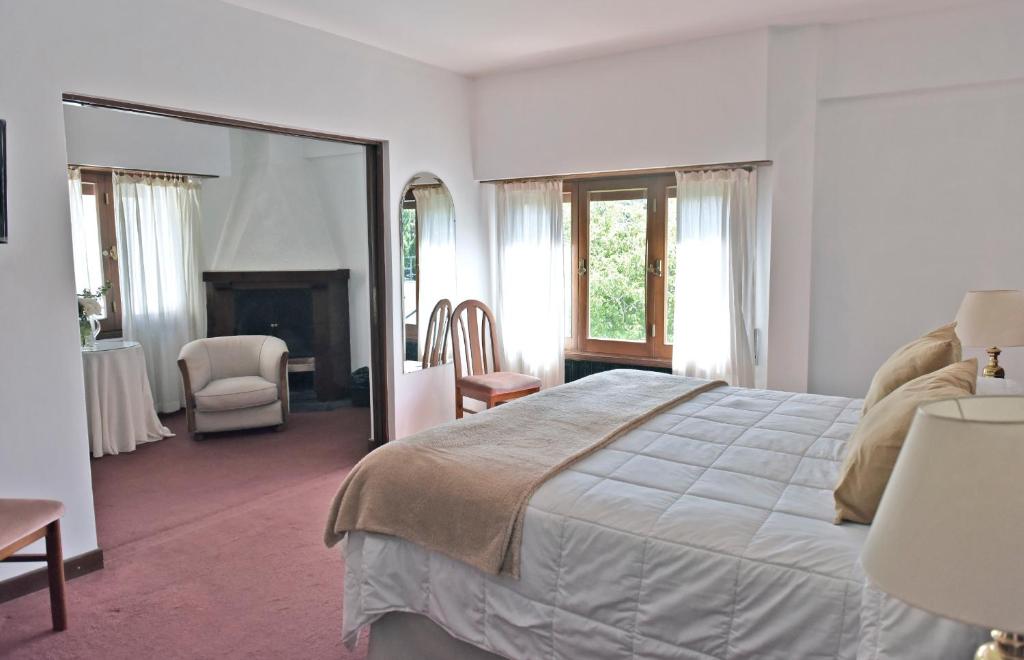 una camera con un grande letto e uno specchio di Hotel Caupolican by Visionnaire a San Martín de los Andes