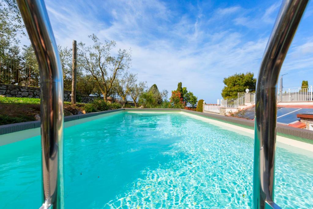 ein Pool in einem Haus mit blauem Wasser in der Unterkunft AMORE RENTALS - Resort Ravenna - The Villa in Massa Lubrense