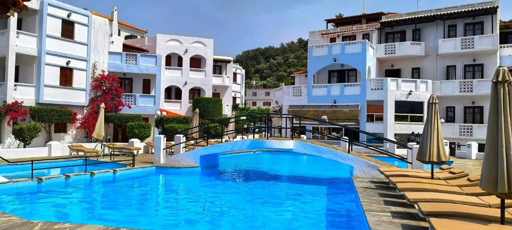 a swimming pool in front of some buildings at Anema By The Sea Guesthouse in Karlovasi