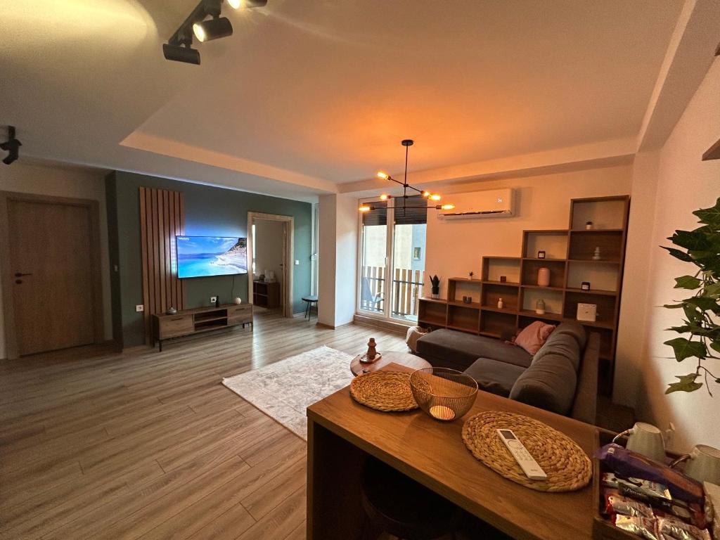 Adora's Apartment Mavrovo في مافروفو: غرفة معيشة مع أريكة وتلفزيون