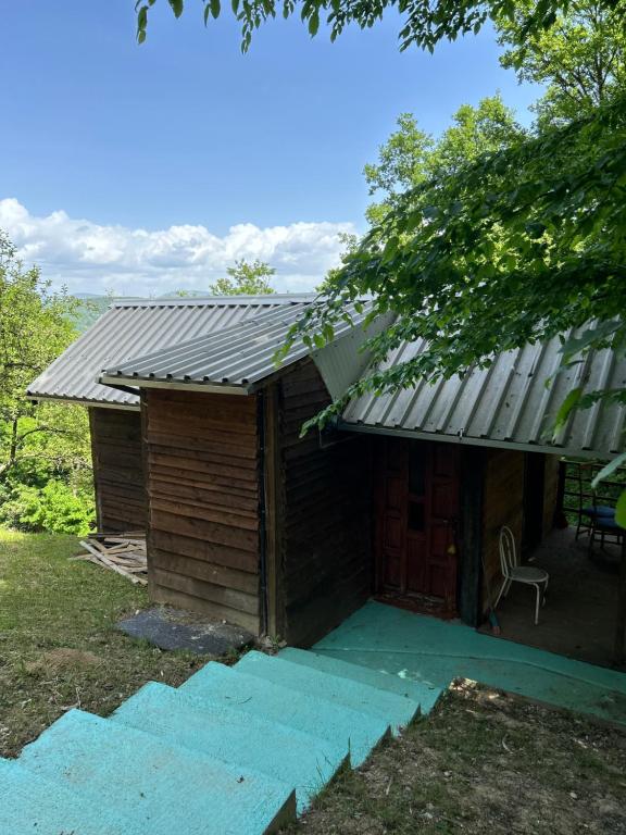a small wooden cabin with a metal roof at Forest House Ninokristali in Visoko
