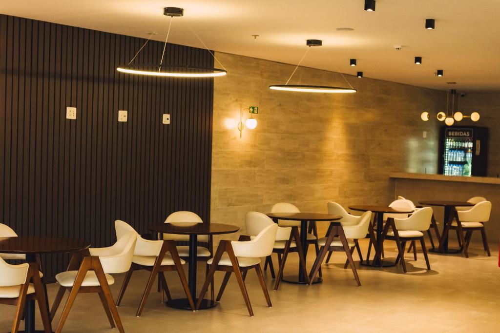 un groupe de tables et de chaises dans un restaurant dans l'établissement Britto Hotel, à Aparecida