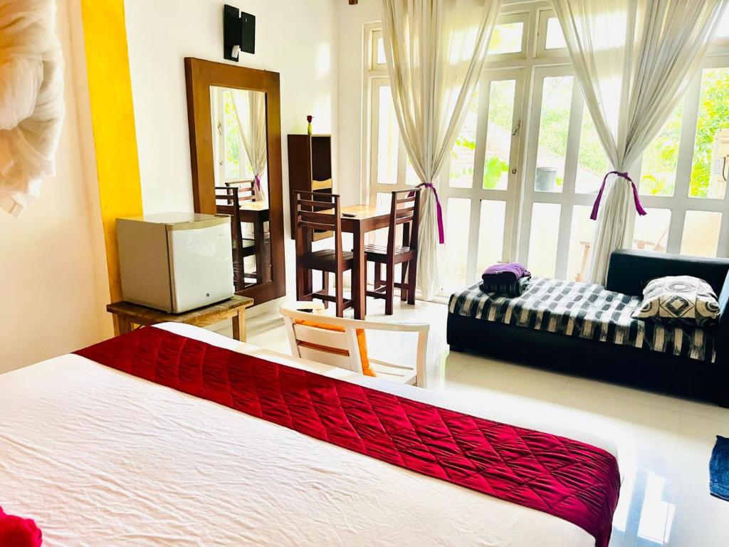 a bedroom with a bed and a living room at Sithila Villa in Mount Lavinia