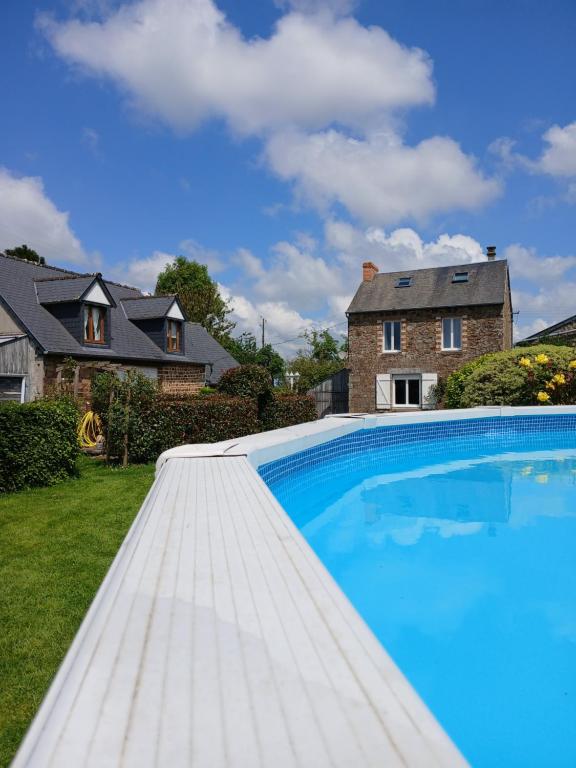 - une piscine dans la cour d'une maison dans l'établissement Le Jardin B&B, à Isigny-le-Buat