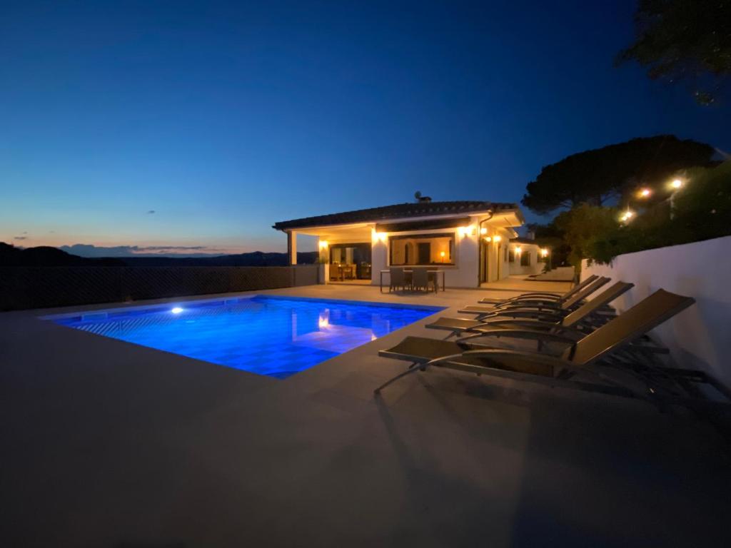 una villa con piscina di notte di Villa Pirineus a beautiful villa with pool a Santa Cristina d'Aro