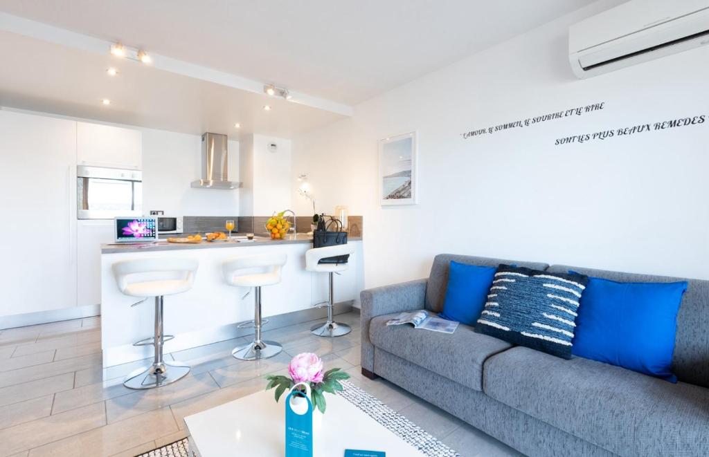 a living room with a couch and a kitchen at Sweett - Maison Blanche I in Juan-les-Pins