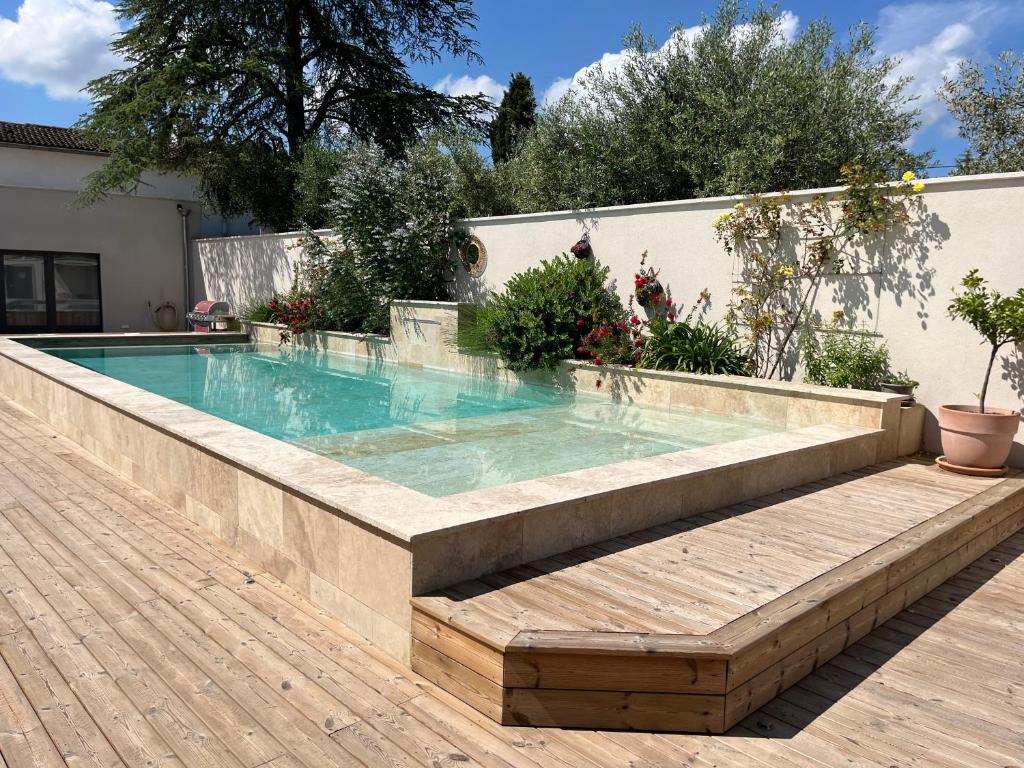 a swimming pool with a bench next to a house at Les Logis de Cocagne in Saint-Rémy-de-Provence