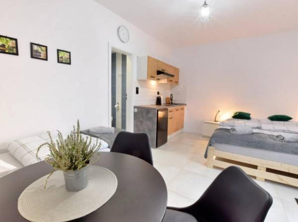 - un salon avec une table, des chaises et un lit dans l'établissement Mini Apartament Pod 13, à Polanica-Zdrój